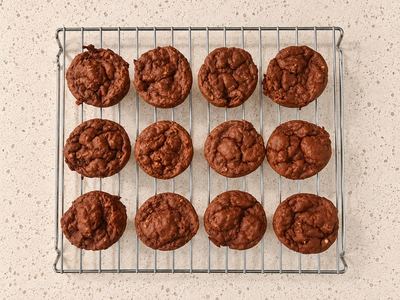 Twelve banana chocolate protein muffins cooling on a wire rack